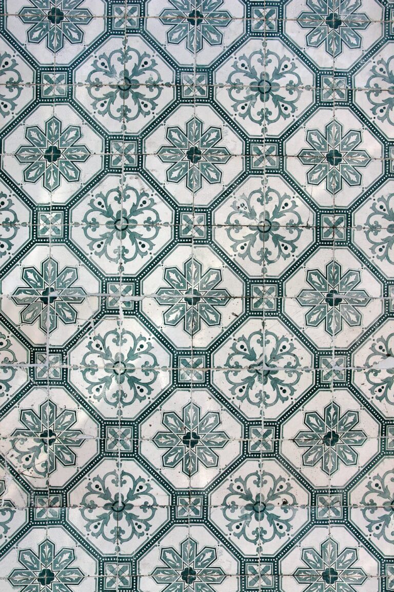 A close up of a tile with green and white designs.