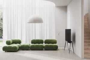 A living room with green furniture and white walls.